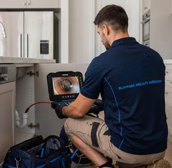 Plumber clearing a blocked toilet in a Cronulla bathroom